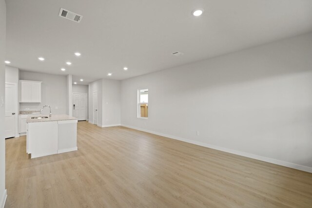 17824 Lionheart Rd, Conroe, TX 77306 - unfurnished living room featuring a sink, baseboards, recessed lighting, and visible vents