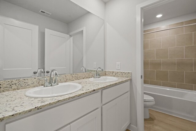 17824 Lionheart Rd, Conroe, TX 77306 - bathroom featuring double vanity, toilet, visible vents, and a sink