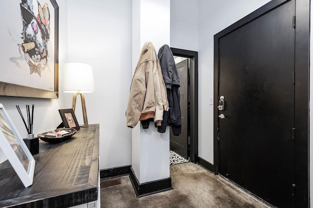 entryway with unfinished concrete floors and baseboards
