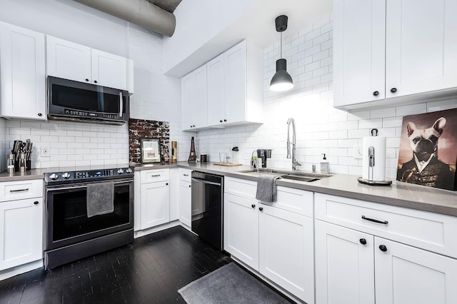 kitchen featuring stainless steel appliances, a sink, dark wood-type flooring, decorative backsplash, and white cabinetry