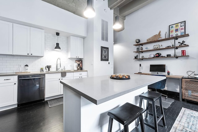 kitchen with a sink, dishwasher, a kitchen bar, white cabinetry, and visible vents