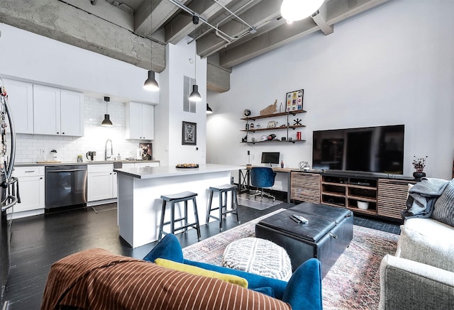 living room featuring a towering ceiling, built in study area, and dark wood-style flooring