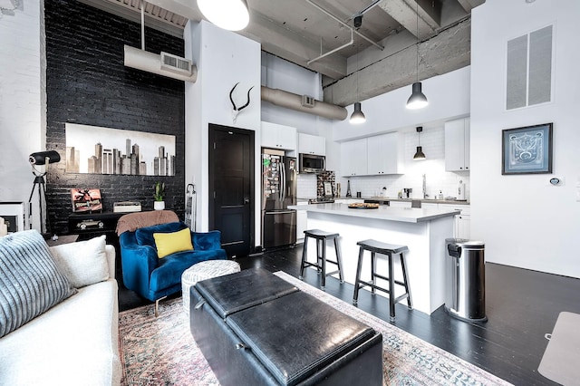 living room featuring visible vents, a towering ceiling, and dark wood-style flooring