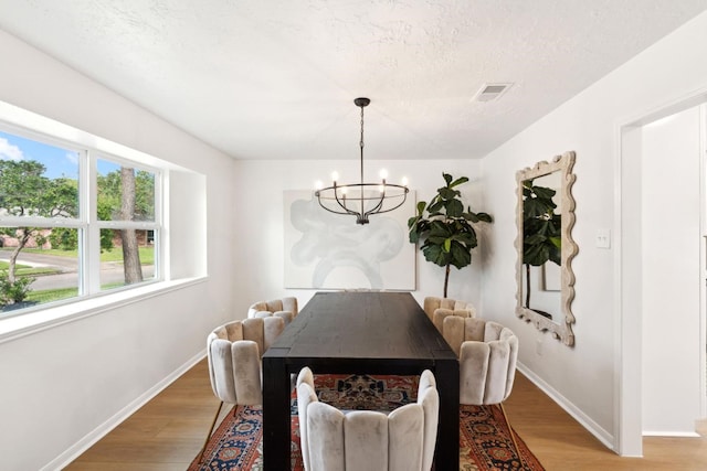 5606 Arbor Vitae Dr, Houston, TX 77092 - dining area with a chandelier, light wood-style flooring, and a textured ceiling