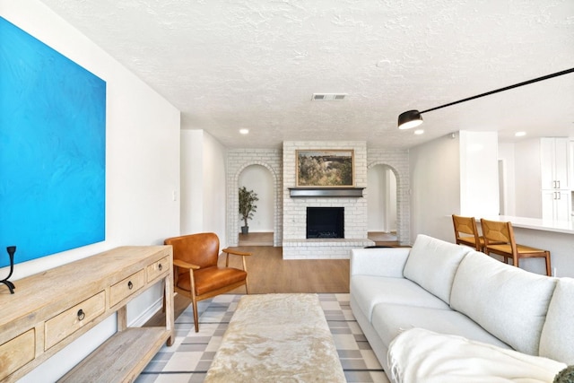 5606 Arbor Vitae Dr, Houston, TX 77092 - living area with arched walkways, a fireplace, wood finished floors, a textured ceiling, and recessed lighting
