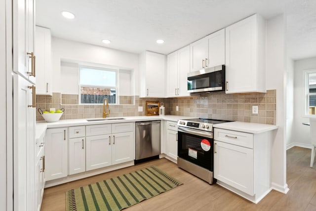 5606 Arbor Vitae Dr, Houston, TX 77092 - kitchen featuring stainless steel appliances, light wood-style flooring, white cabinetry, light countertops, and recessed lighting