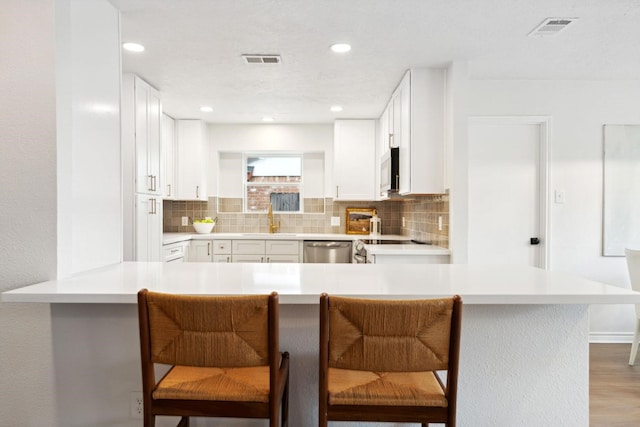5606 Arbor Vitae Dr, Houston, TX 77092 - kitchen with stainless steel appliances, backsplash, a kitchen breakfast bar, a peninsula, and recessed lighting