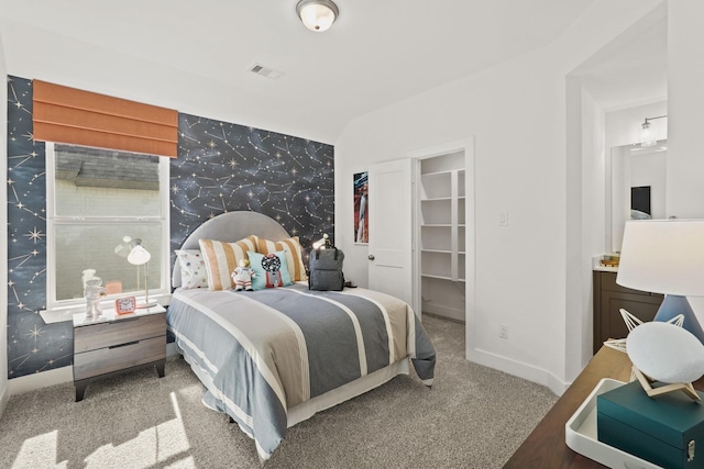 500 Dove Meadow Ln, Katy, TX 77493 - carpeted bedroom featuring wallpapered walls, an accent wall, a spacious closet, and baseboards