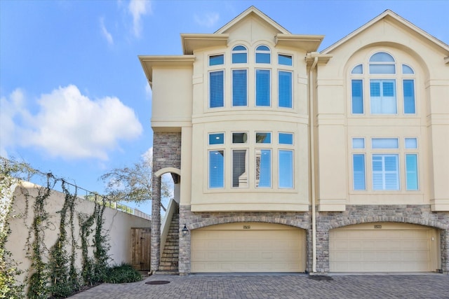 5768 Sugar Hill Dr, Houston, TX 77057 - view of front of home featuring stairway, stone siding, decorative driveway, and stucco siding