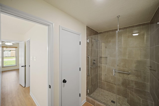 13510 Cedar Point Dr, Cypress, TX 77429 - full bath with baseboards, wood finished floors, a stall shower, and ceiling fan
