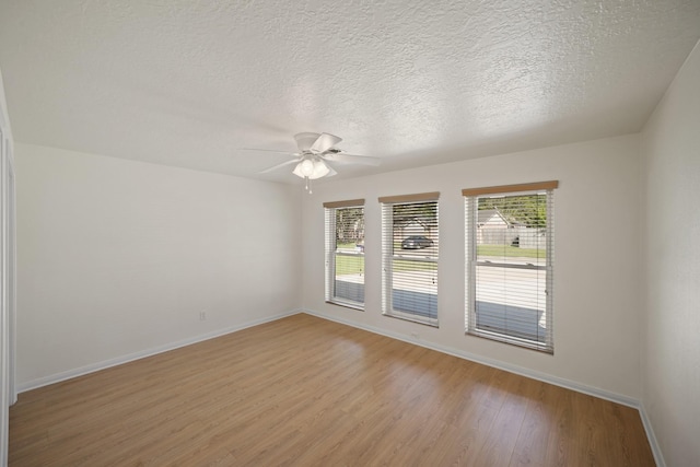 13510 Cedar Point Dr, Cypress, TX 77429 - empty room with baseboards, a ceiling fan, a textured ceiling, and light wood-type flooring