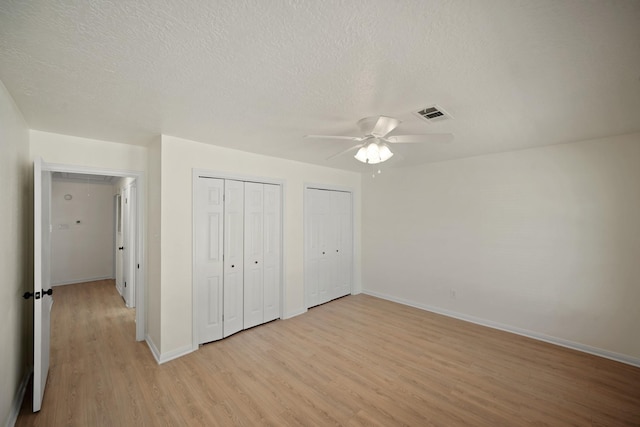 13510 Cedar Point Dr, Cypress, TX 77429 - unfurnished bedroom featuring light wood-style flooring, multiple closets, baseboards, and visible vents