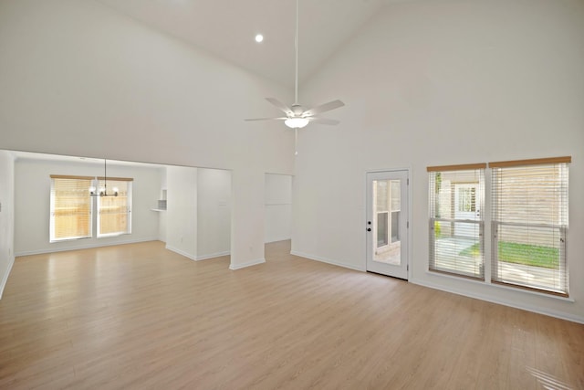 13510 Cedar Point Dr, Cypress, TX 77429 - unfurnished living room featuring high vaulted ceiling, a healthy amount of sunlight, light wood finished floors, and ceiling fan with notable chandelier