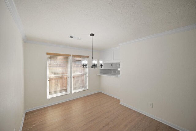 13510 Cedar Point Dr, Cypress, TX 77429 - unfurnished dining area with an inviting chandelier, visible vents, ornamental molding, light wood-style floors, and baseboards