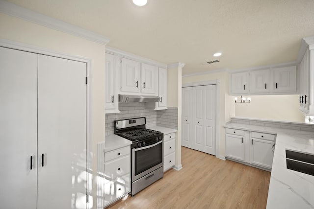13510 Cedar Point Dr, Cypress, TX 77429 - kitchen with light wood finished floors, visible vents, white cabinetry, gas stove, and under cabinet range hood