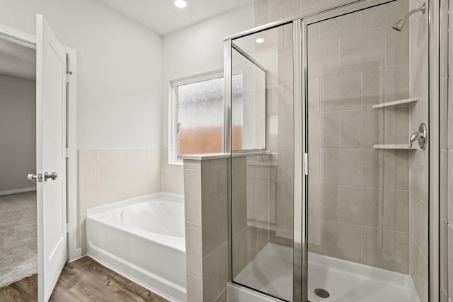 14212 Spring Valley Dr, Conroe, TX 77303 - full bathroom featuring a bath, a stall shower, wood finished floors, and recessed lighting