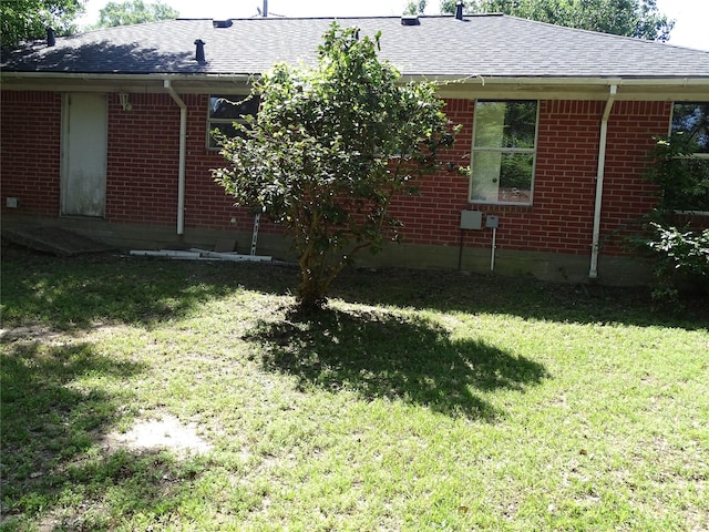 117 N Forest Dr, Willis, TX 77378 - exterior space featuring roof with shingles, a yard, and brick siding