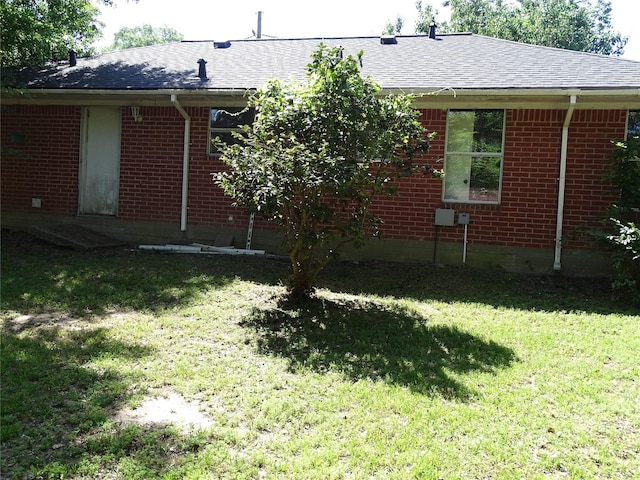 117 N Forest Dr, Willis, TX 77378 - rear view of property with roof with shingles, brick siding, and a lawn