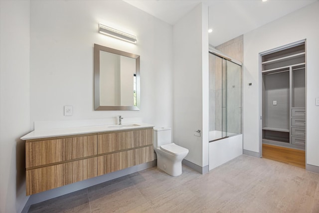310 E Cowan Dr, Houston, TX 77007 - full bath with enclosed tub / shower combo, vanity, toilet, and wood finished floors