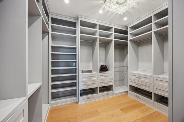 310 E Cowan Dr, Houston, TX 77007 - walk in closet featuring light wood-style flooring and an inviting chandelier