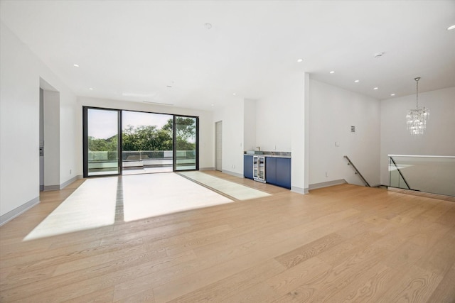 310 E Cowan Dr, Houston, TX 77007 - unfurnished living room with recessed lighting, light wood finished floors, a notable chandelier, and baseboards