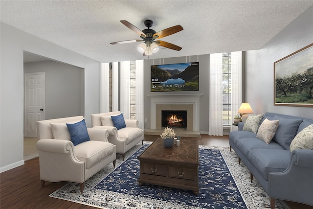 10223 Dude Rd, Houston, TX 77064 - living area with baseboards, a lit fireplace, a textured ceiling, a ceiling fan, and wood finished floors