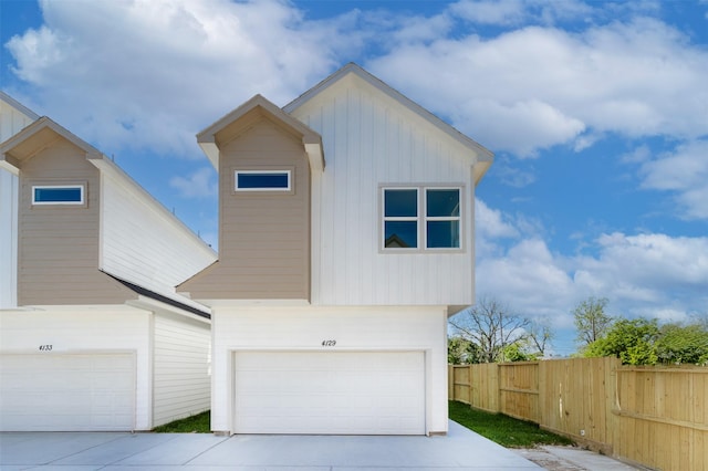 4129 E Toliver St, Houston, TX 77016 - modern home featuring board and batten siding, an attached garage, fence, and concrete driveway