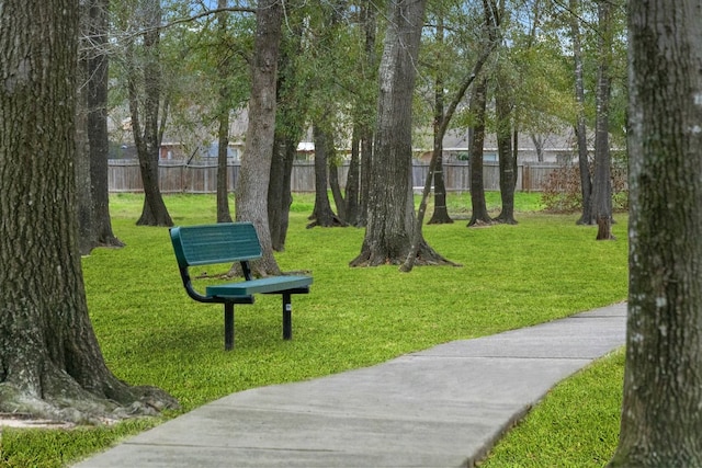 view of property's community featuring a yard and fence