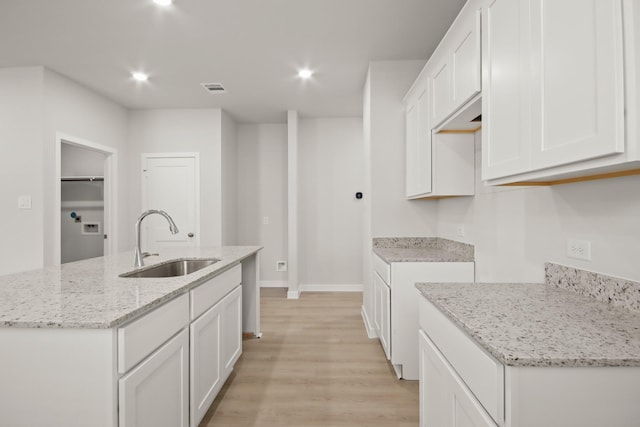 17836 Lionheart Rd, Conroe, TX 77306 - kitchen featuring a sink, light wood-type flooring, a center island with sink, light stone countertops, and recessed lighting