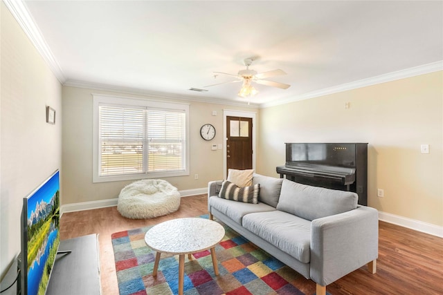 living room featuring crown molding, ceiling fan, wood finished floors, and baseboards