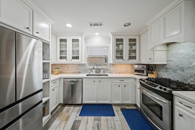 kitchen with visible vents, light countertops, white cabinetry, a sink, and appliances with stainless steel finishes