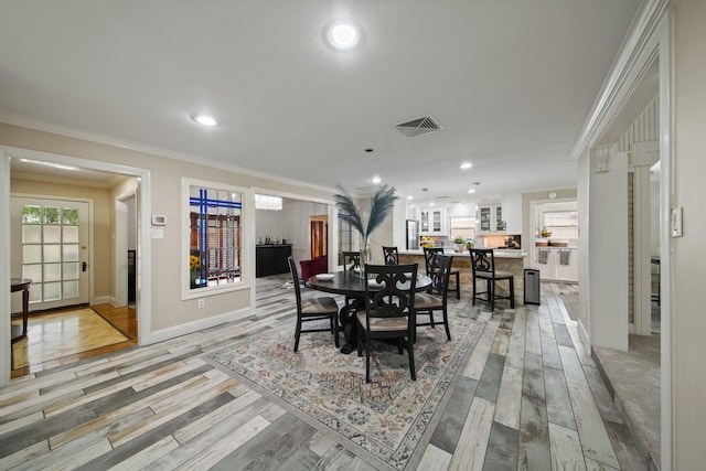 dining area with crown molding, light wood finished floors, recessed lighting, and visible vents