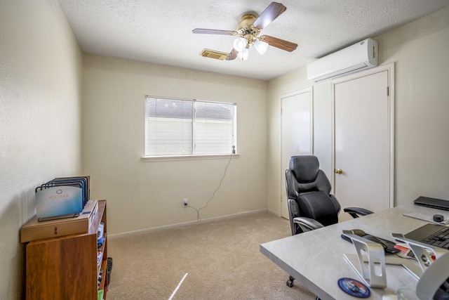 home office featuring visible vents, a wall mounted air conditioner, a ceiling fan, a textured ceiling, and carpet floors