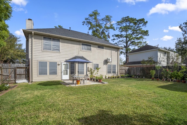 back of house featuring a chimney, a patio area, a fenced backyard, and a lawn