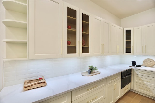 603 Neyland St, Houston, TX 77022 - kitchen with oven, backsplash, and white cabinets