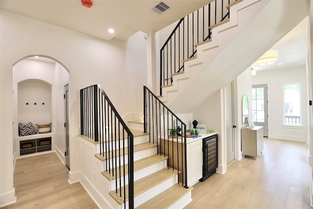 603 Neyland St, Houston, TX 77022 - stairs with beverage cooler, wood finished floors, baseboards, recessed lighting, and a dry bar
