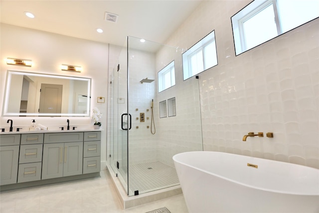 603 Neyland St, Houston, TX 77022 - full bathroom with a shower stall, double vanity, a freestanding bath, tile patterned floors, and recessed lighting