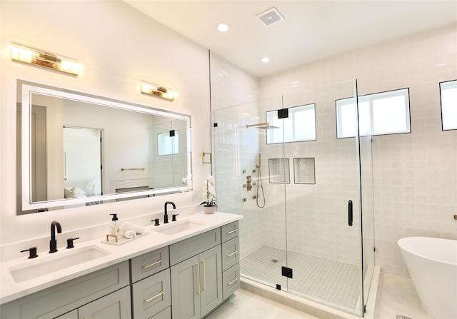 603 Neyland St, Houston, TX 77022 - ensuite bathroom with double vanity, a shower stall, a freestanding tub, and recessed lighting