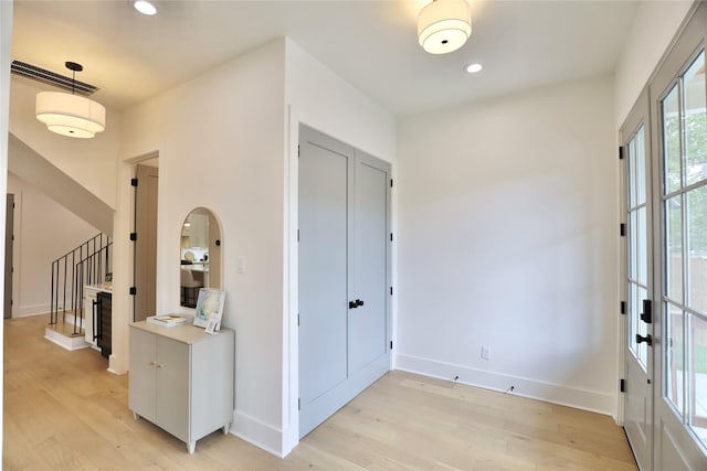 603 Neyland St, Houston, TX 77022 - foyer entrance with light wood-style flooring, stairs, baseboards, recessed lighting, and arched walkways