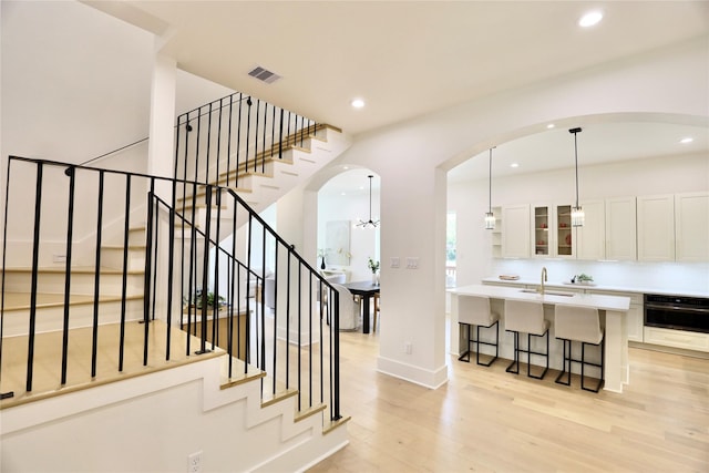 603 Neyland St, Houston, TX 77022 - stairway featuring wood finished floors, arched walkways, recessed lighting, and baseboards