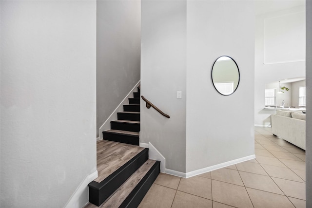 5914 Prince Place Dr, Rosenberg, TX 77471 - staircase with arched walkways, tile patterned flooring, a towering ceiling, and baseboards