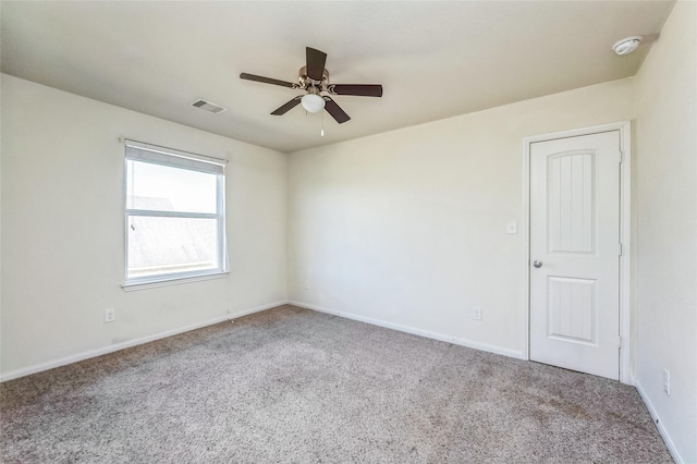 carpeted spare room featuring visible vents, ceiling fan, and baseboards