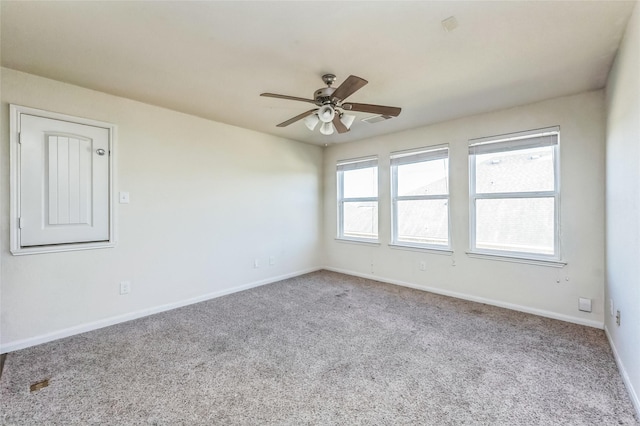 spare room featuring ceiling fan, carpet, and baseboards