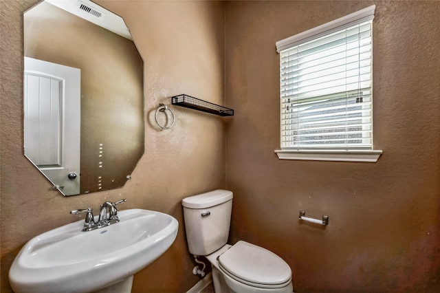 bathroom featuring a sink, visible vents, and toilet