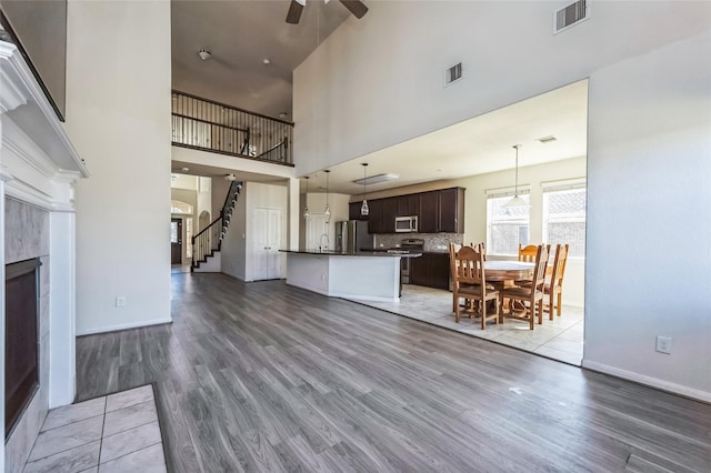 living area with light wood finished floors, a ceiling fan, and visible vents