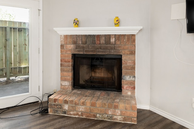 interior details featuring baseboards, wood finished floors, and a fireplace