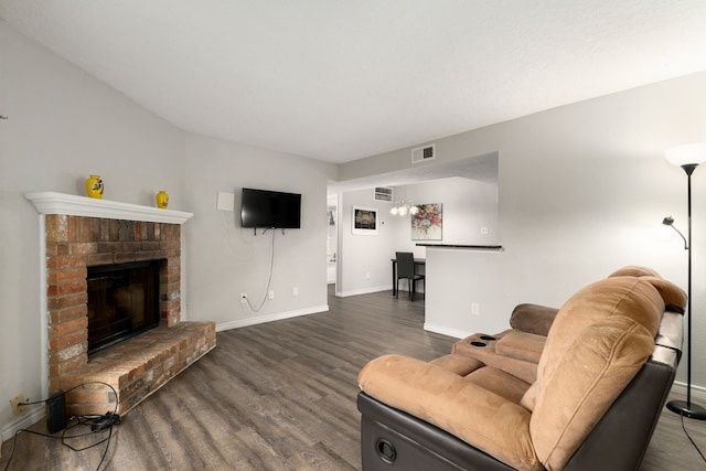living area featuring baseboards, wood finished floors, visible vents, and a fireplace