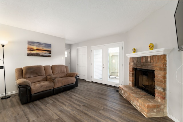 living room with baseboards, french doors, dark wood-style floors, and a brick fireplace