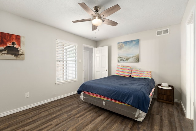 bedroom with baseboards, a ceiling fan, wood finished floors, and visible vents