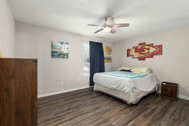 bedroom with dark wood finished floors, a ceiling fan, and baseboards